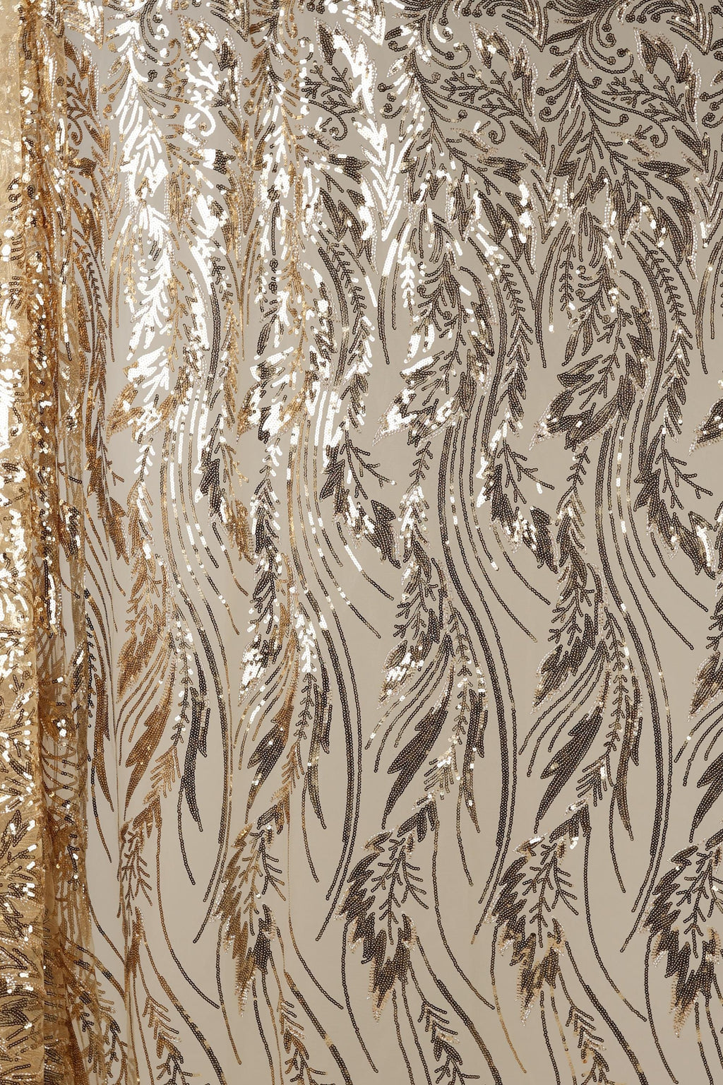 a close-up view of a fabric with a repeating pattern of gold and black sequin designs. The pattern consists of various shapes and lines, creating a visually striking and intricate design. The fabric appears to be a sheer material, with a metallic sheen that adds a touch of elegance and sophistication to the overall appearance.