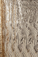 a close-up view of a fabric with a repeating pattern of gold and black sequin designs. The pattern consists of various shapes and lines, creating a visually striking and intricate design. The fabric appears to be a sheer material, with a metallic sheen that adds a touch of elegance and sophistication to the overall appearance.