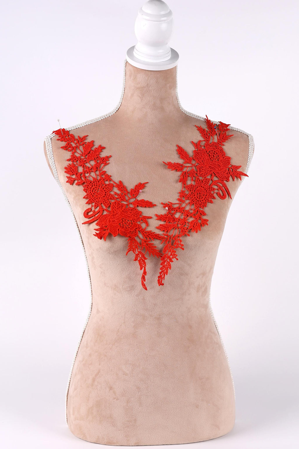 A mannequin wearing a red floral embroidered vest.