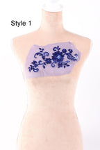 A mannequin with a decorative fabric patch on its chest, featuring a floral pattern in shades of blue.