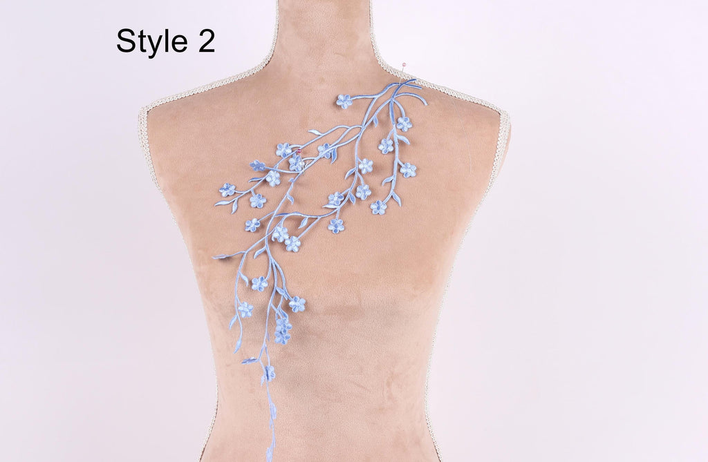 A mannequin with a floral embroidered on its back, featuring blue flowers and branches.
