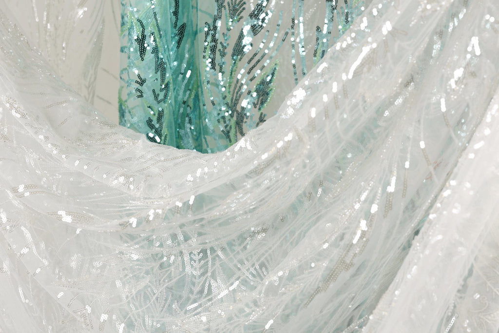 a close-up view of a white fabric with sequin patterns, creating a visually striking and intricate design.