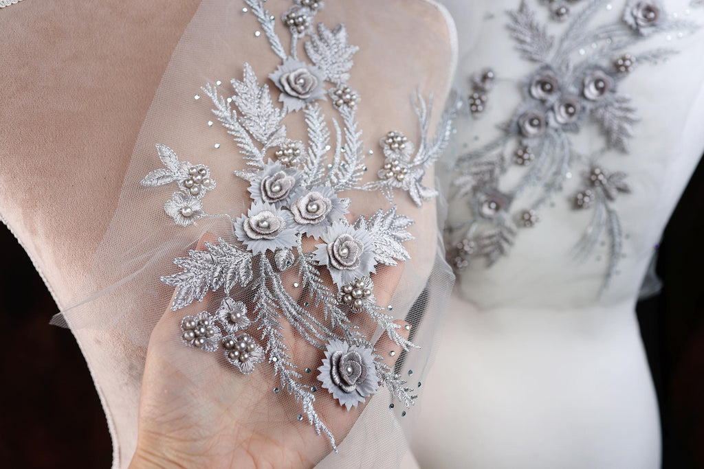 a close up of a person's wedding dress with flowers on it