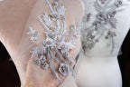 a close up of a person's wedding dress with flowers on it
