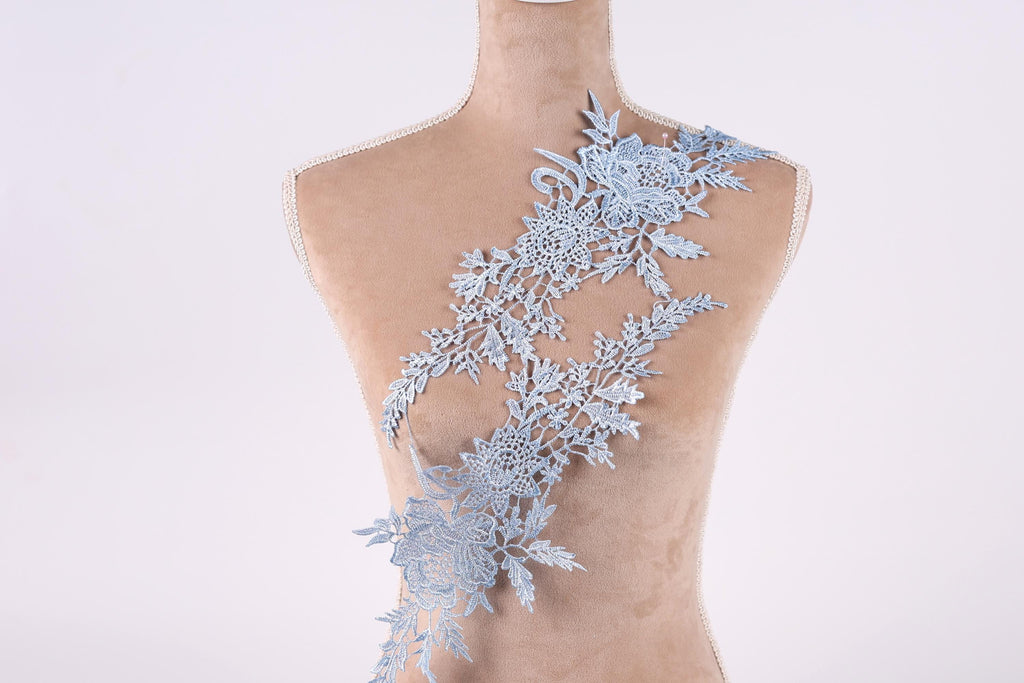 A mannequin torso with a delicate, intricate lace pattern adorning the back.