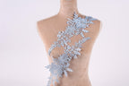 A mannequin torso with a delicate, intricate lace pattern adorning the back.