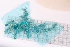 a piece of fabric with a floral design, including blue and green flowers, and a ruler placed on top of it.