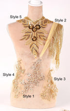 A mannequin wearing a gold and beige embroidered dress with various styles of necklaces and embellishments displayed on it.