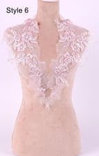 A mannequin wearing a pink lace collar with delicate floral patterns.
