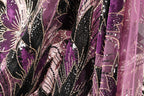The image is a close-up of a fabric with a floral pattern, featuring a mix of purple and black colors. The fabric appears to be made of a shiny, sequined material, giving it a sparkling and luxurious appearance.