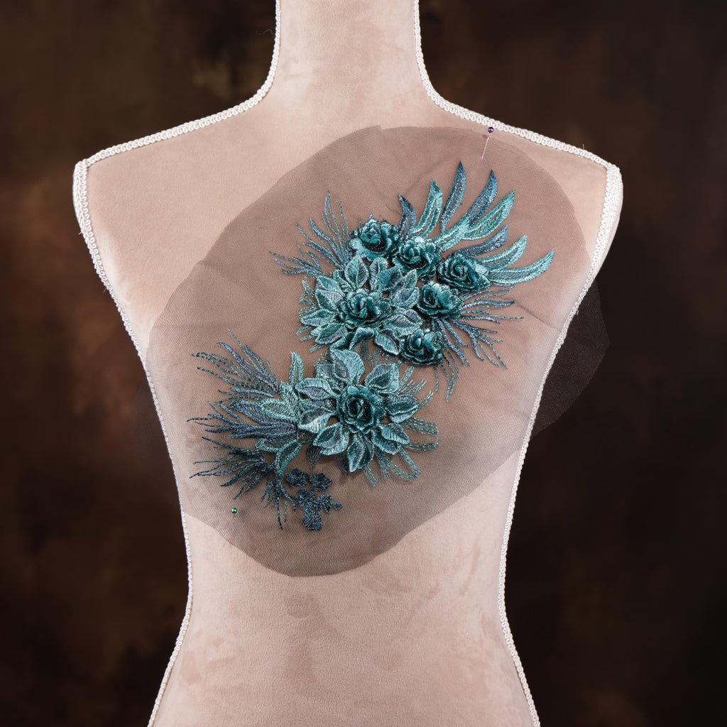 a mannequin with a floral design on its back, including blue flowers and green leaves.