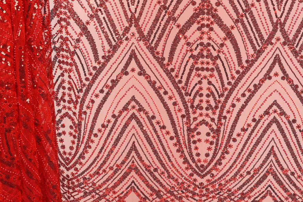 a close-up view of a fabric with a repeating pattern of red and black sequins. The pattern consists of various shapes and designs, creating a visually striking and intricate design.