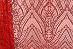 a close-up view of a fabric with a repeating pattern of red and black sequins. The pattern consists of various shapes and designs, creating a visually striking and intricate design.