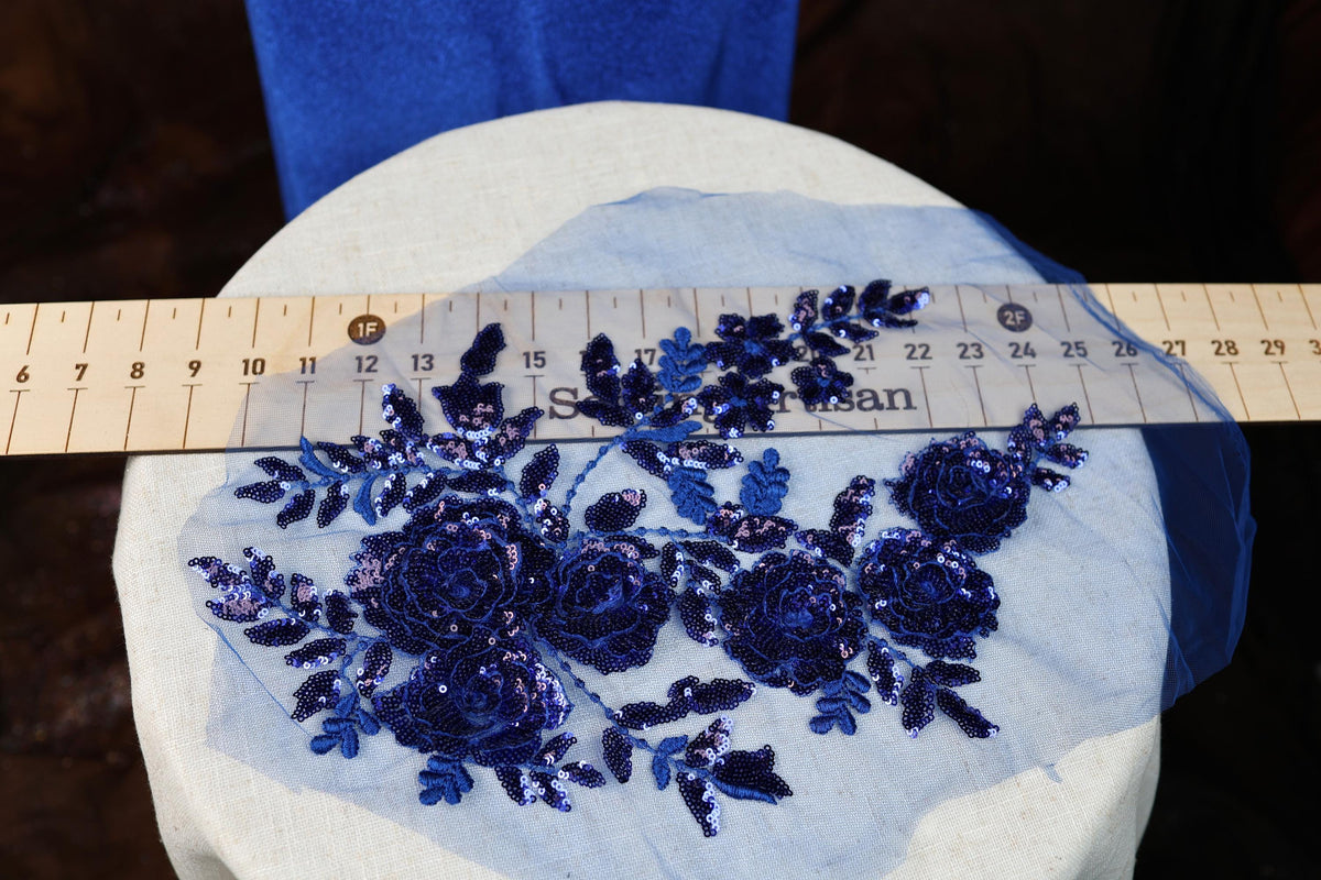 a blue piece of cloth with flowers on it next to a ruler