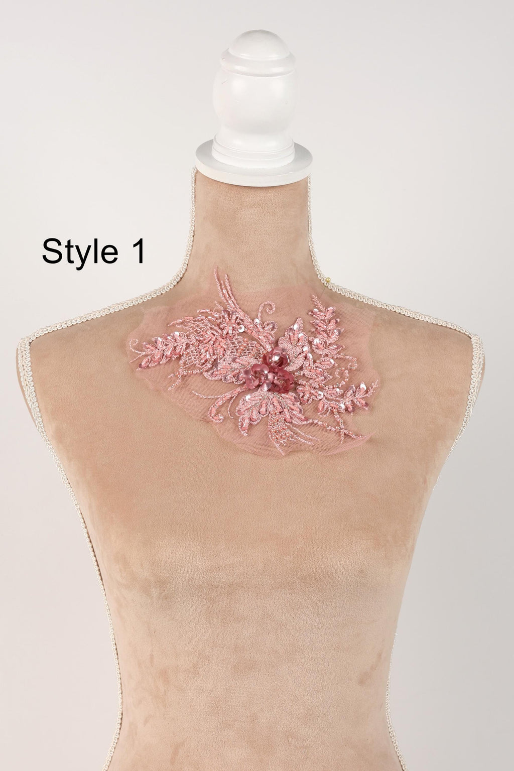 A mannequin with a pink floral embellishment on its neck.