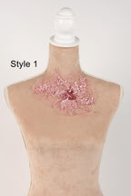 A mannequin with a pink floral embellishment on its neck.