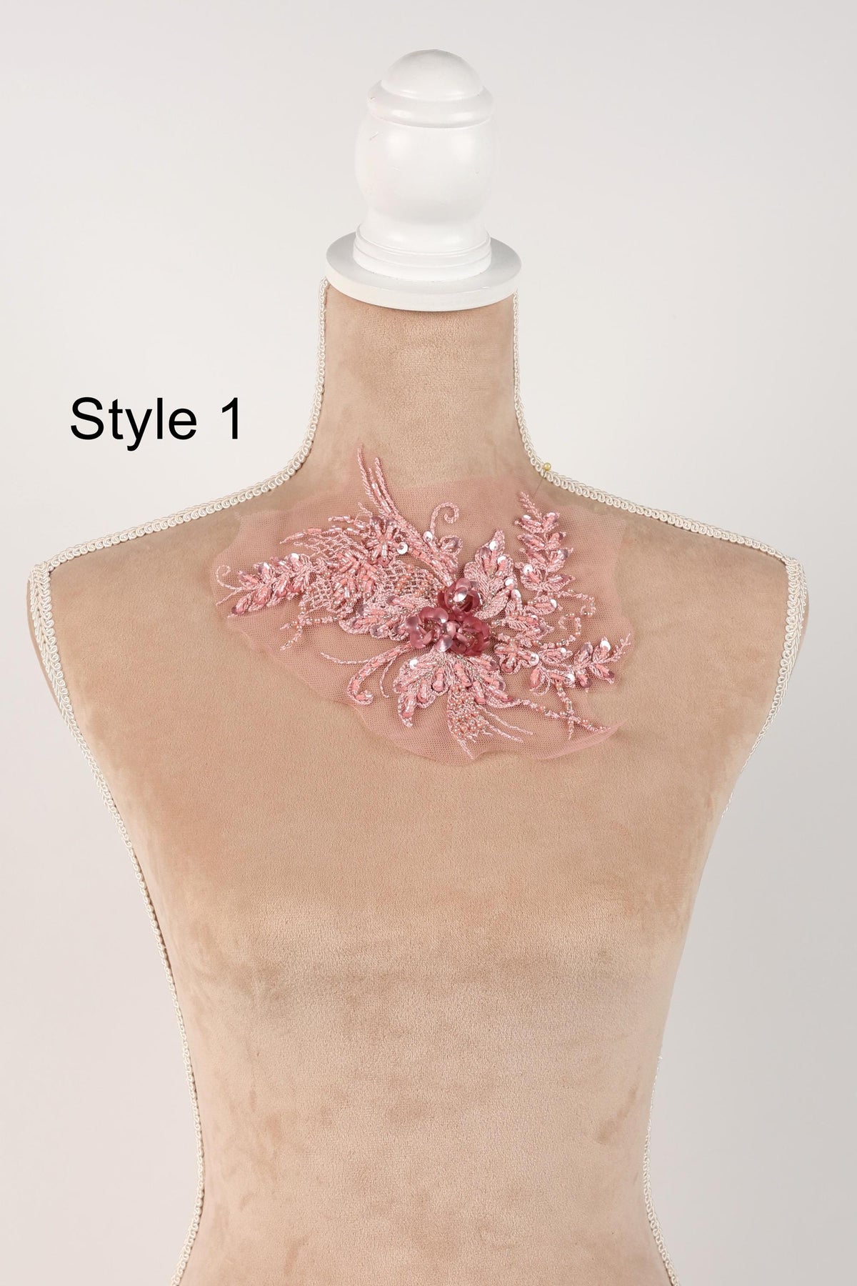 A mannequin with a pink floral embellishment on its neck.
