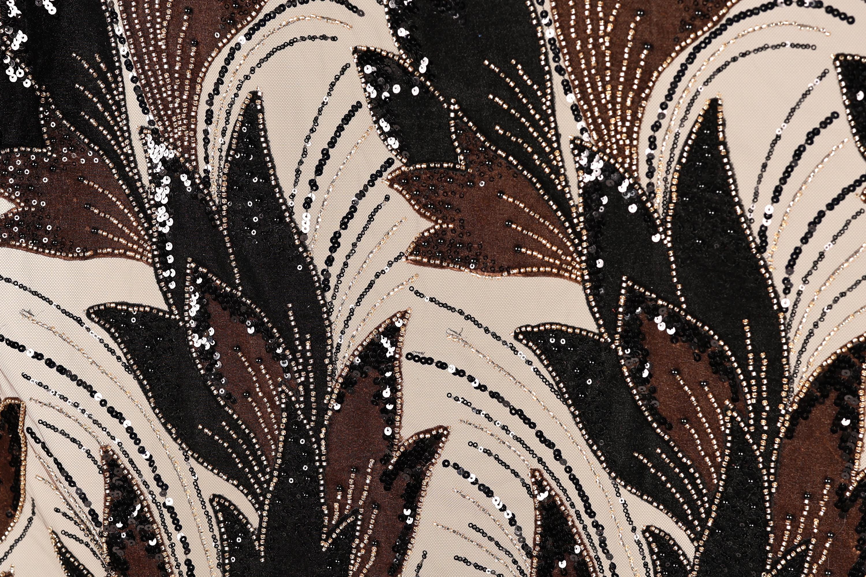 a close-up view of a fabric with a striking pattern of brown and black sequins and beads, creating a visually captivating and intricate design.
