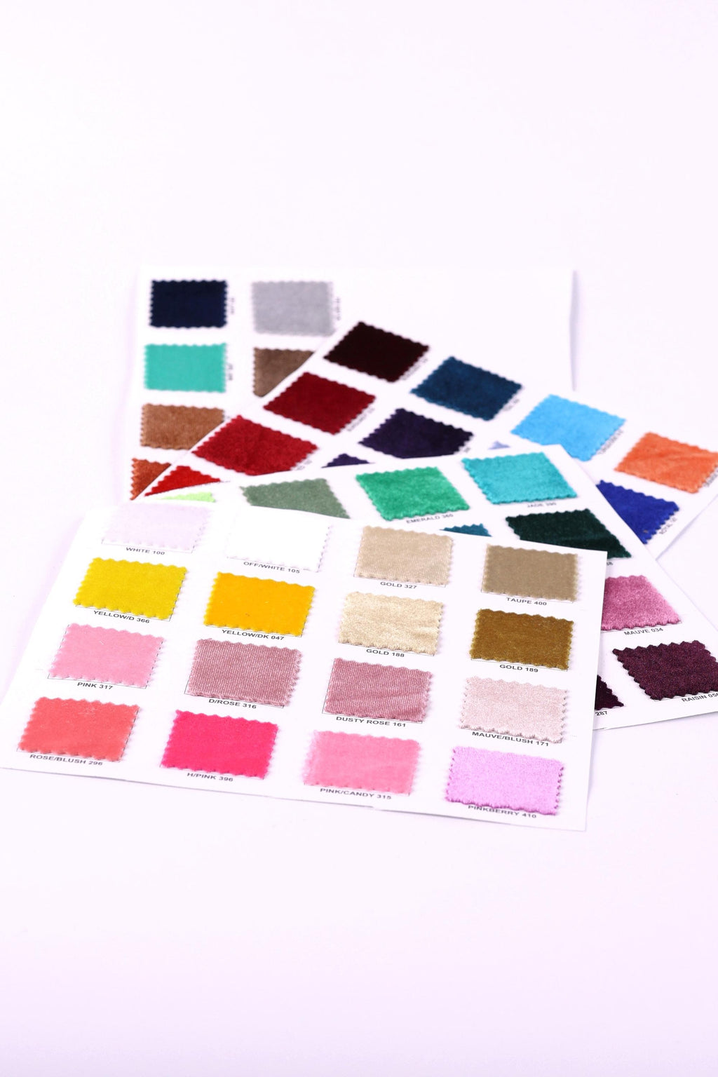a collection of fabric swatches in various colors, including pink, blue, green, yellow, and more, arranged on a white background.