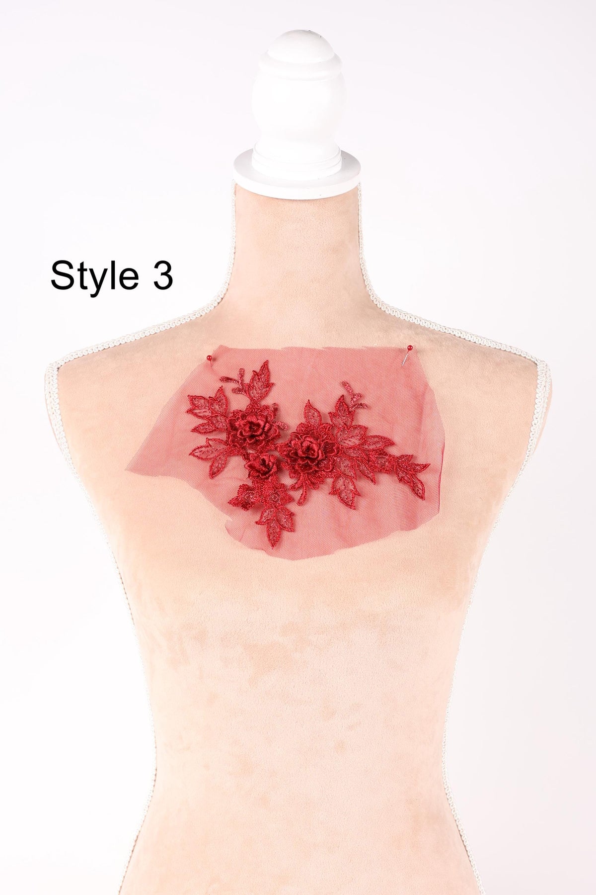 A mannequin with a red floral embroidered on its chest.