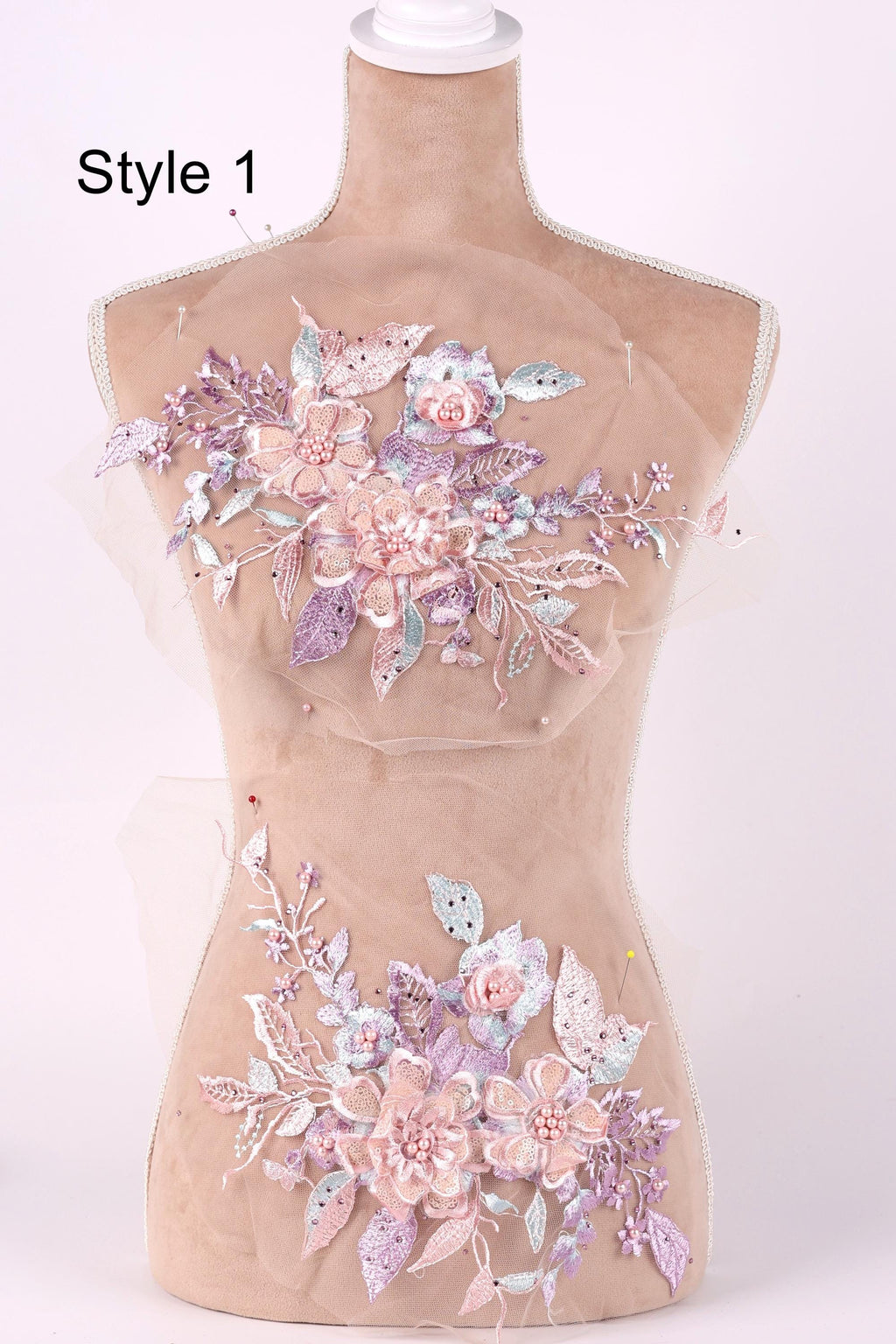 A mannequin with a floral design on its bust, featuring a variety of pink and purple flowers and leaves.