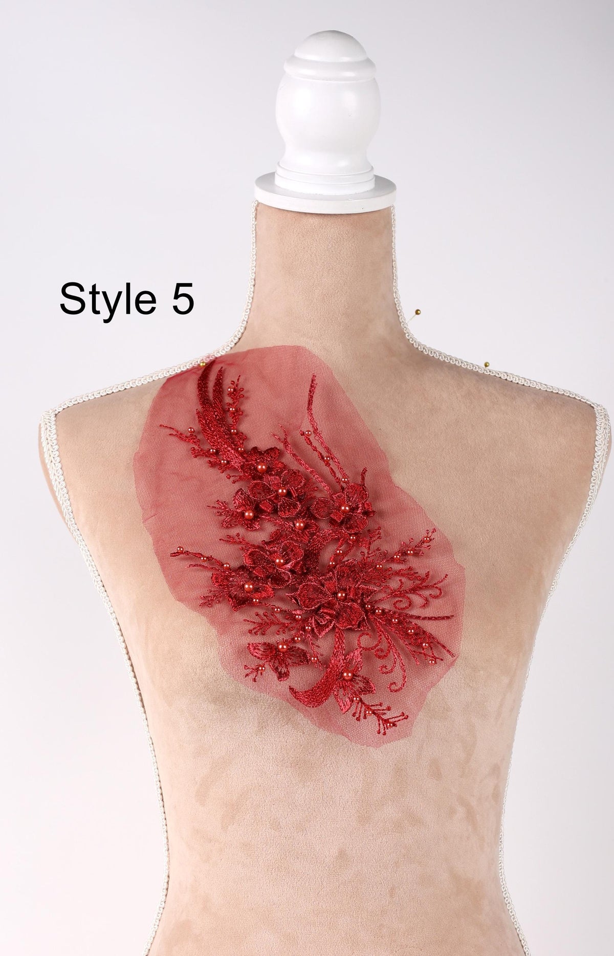 A mannequin with a red floral embellishment on its bust.