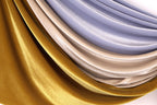 a close-up view of a fabric with a shiny, metallic texture in gold, silver, and blue colors.