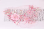 a delicate arrangement of pink flowers and leaves, with a ruler placed in the foreground to provide a sense of scale.
