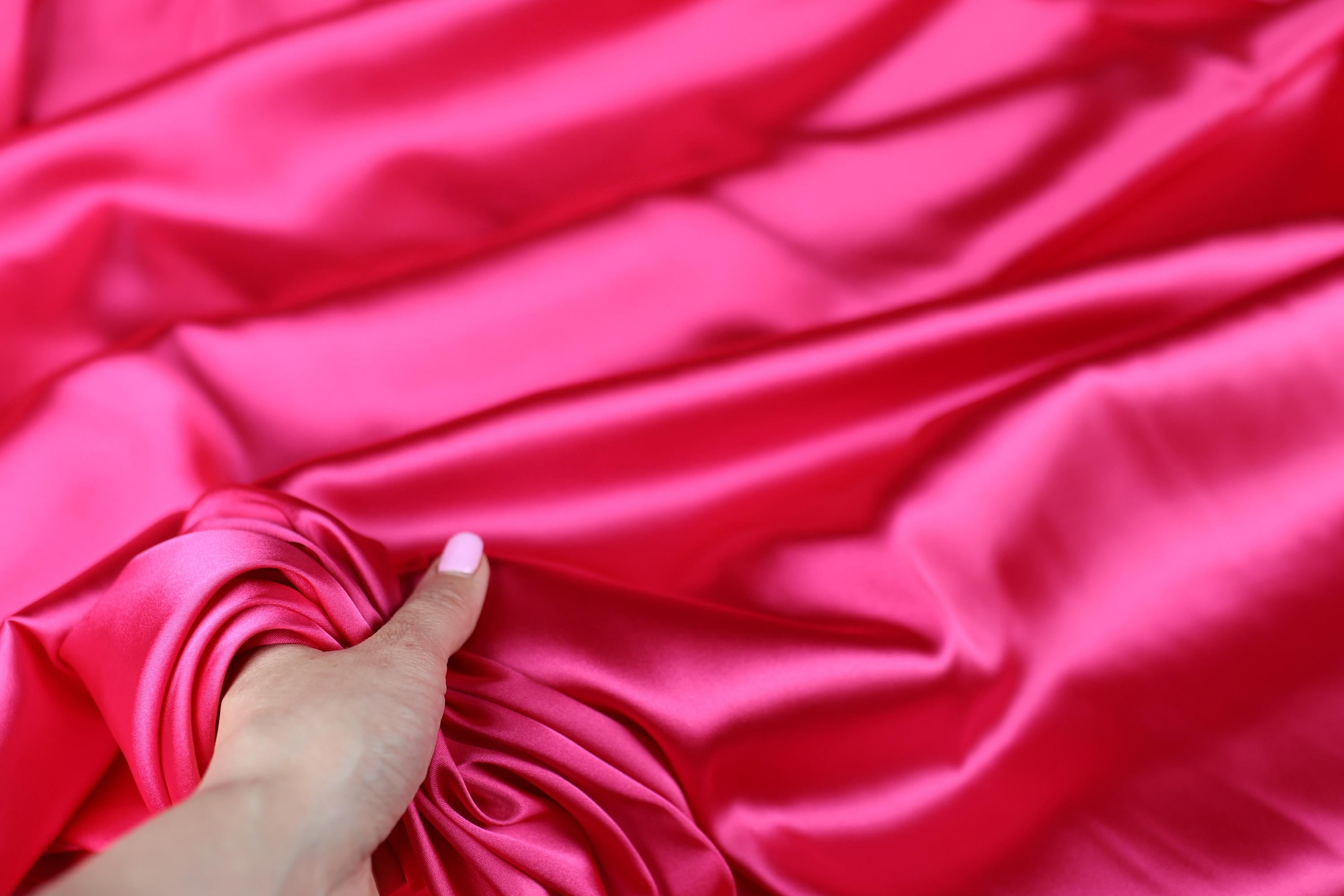a woman's hand holding a pink cloth