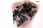 A mannequin with a black lace or sequin floral pattern on its bust area.