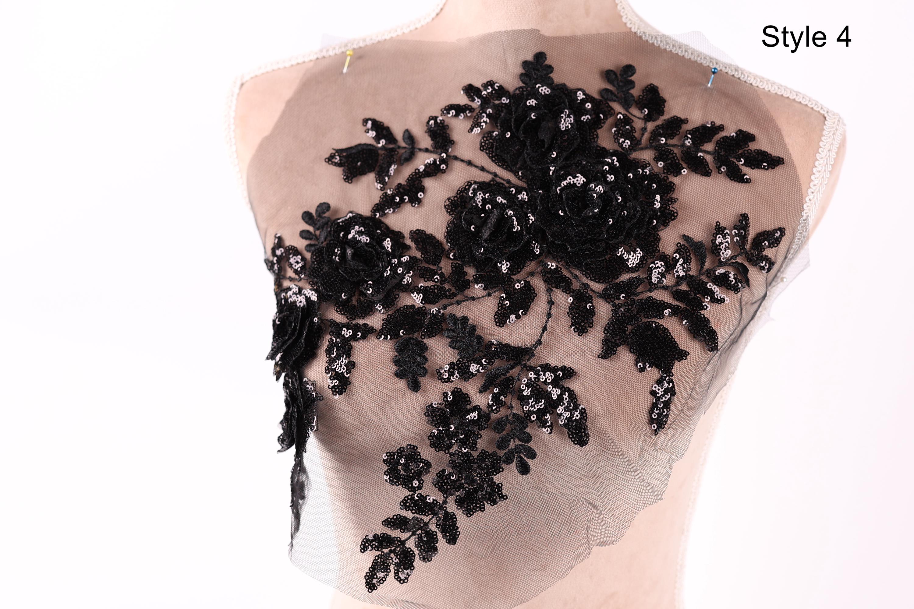 A mannequin with a black lace or sequin floral pattern on its bust area.