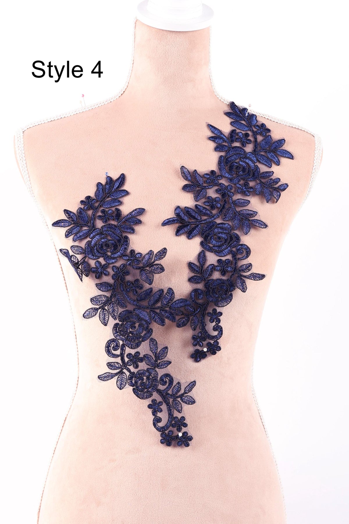 A mannequin wearing a dress with a decorative blue lace overlay.