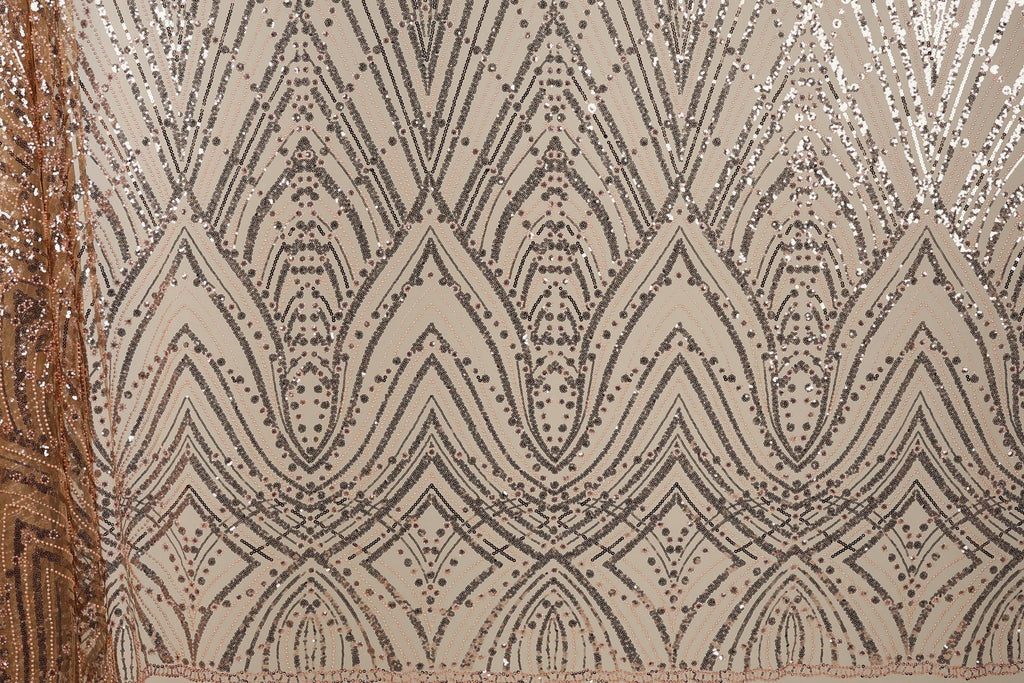 a close-up view of a fabric with a repeating pattern of diamond shapes and small dots in shades of brown and beige. The pattern is intricate and detailed, with the diamonds and dots arranged in a zigzag or diagonal manner. The fabric appears to be made of a shiny, sequined material, which adds to the visual appeal of the design.