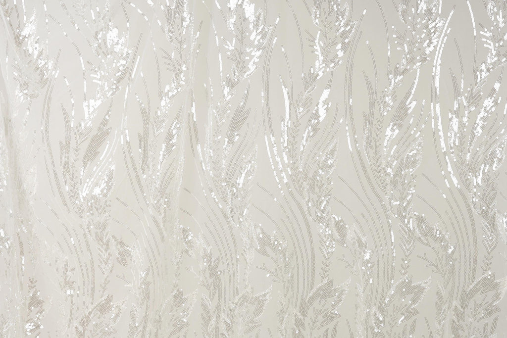 a close-up view of a fabric with a repeating pattern of white and beige lines and shapes, resembling the appearance of grass or leaves.