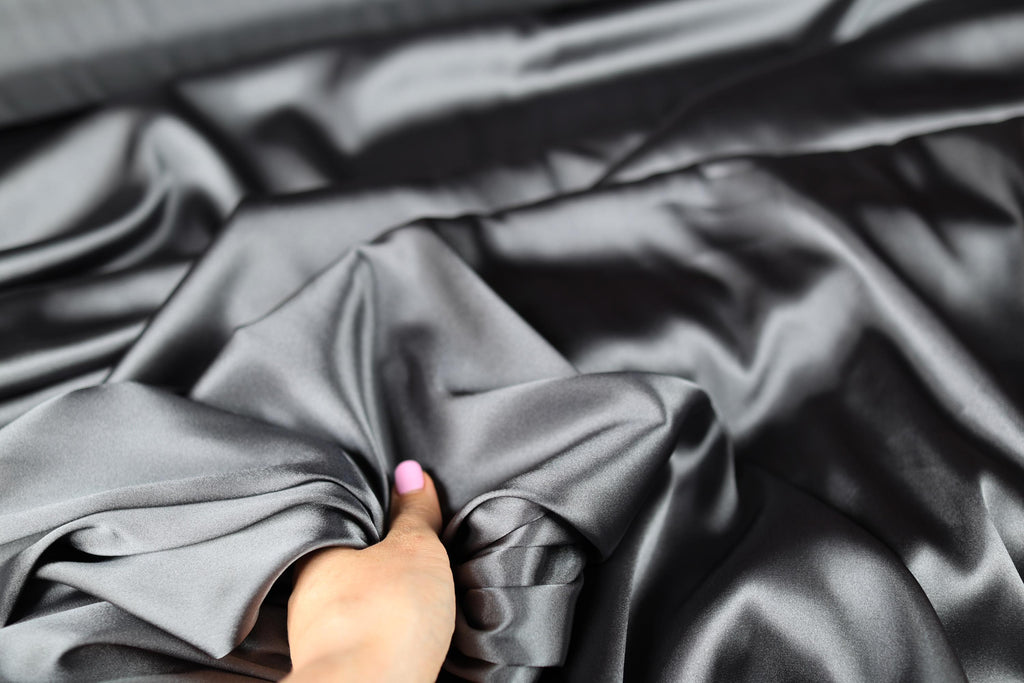 a person&#39;s hand on a black cloth