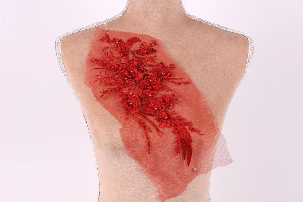 a mannequin torso with a red floral embroidered on it, set against a white background.