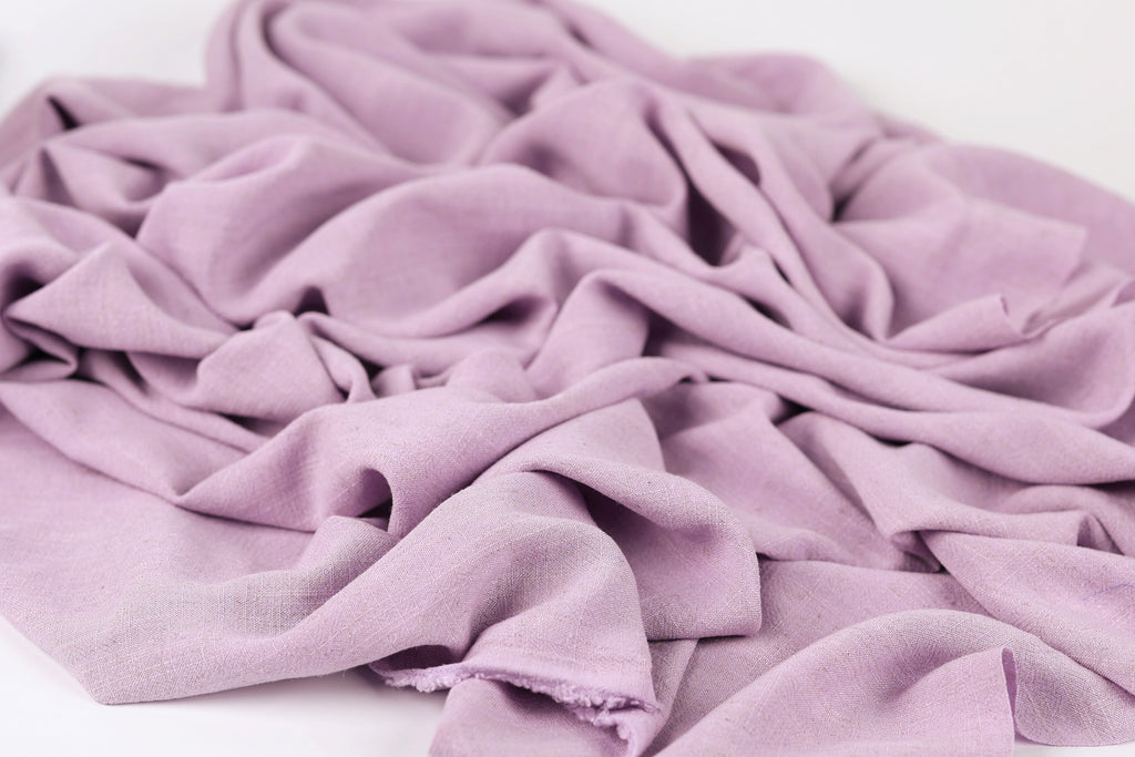 A close-up view of a soft, wrinkled fabric in a light purple color.