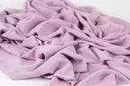 A close-up view of a soft, wrinkled fabric in a light purple color.