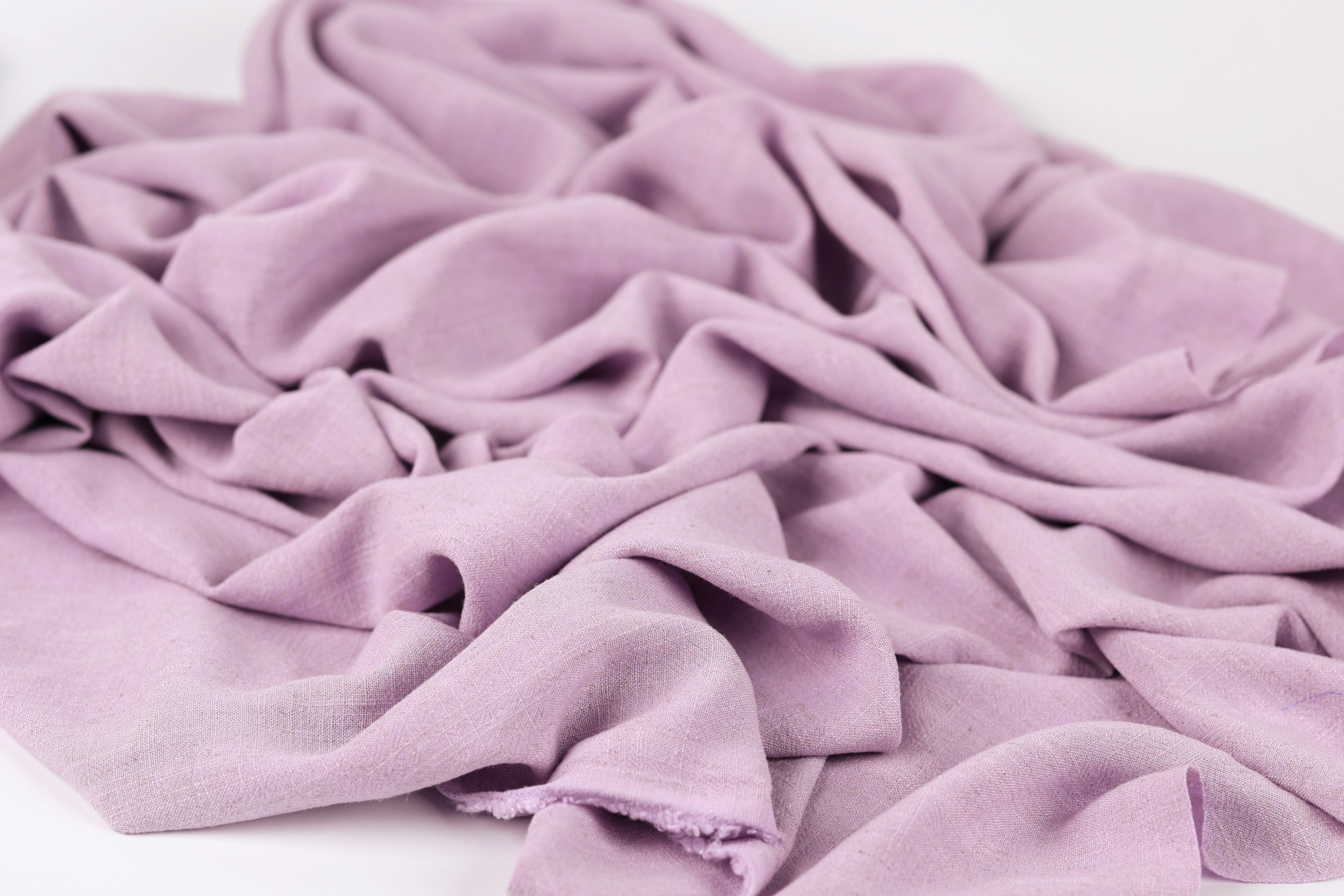 A close-up view of a soft, wrinkled fabric in a light purple color.