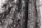 a close-up view of a black and grey sequined fabric, with intricate patterns and designs.