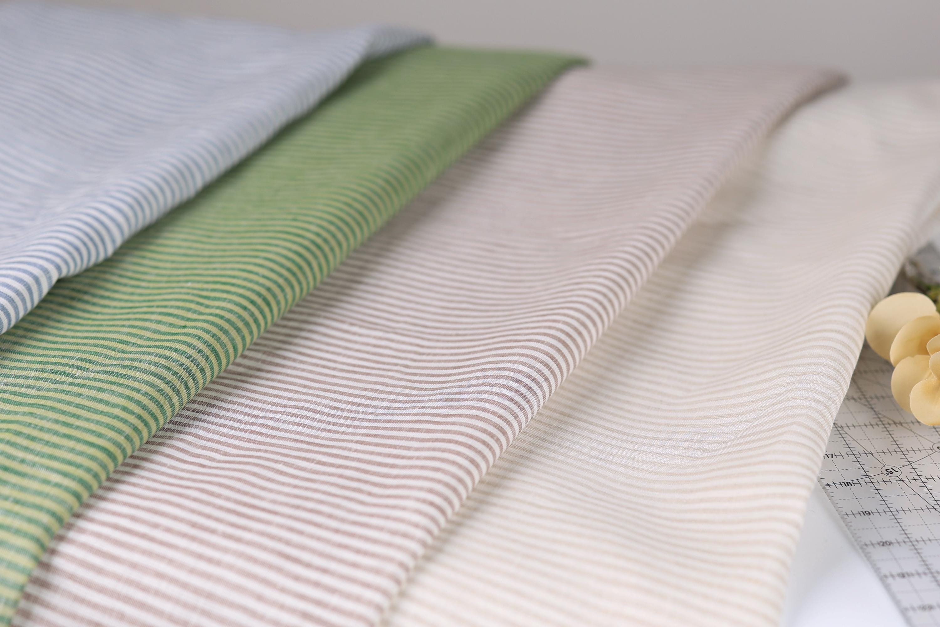 A close-up view of a collection of fabric swatches in various colors and patterns, including stripes, polka dots, and solid colors, arranged on a surface.