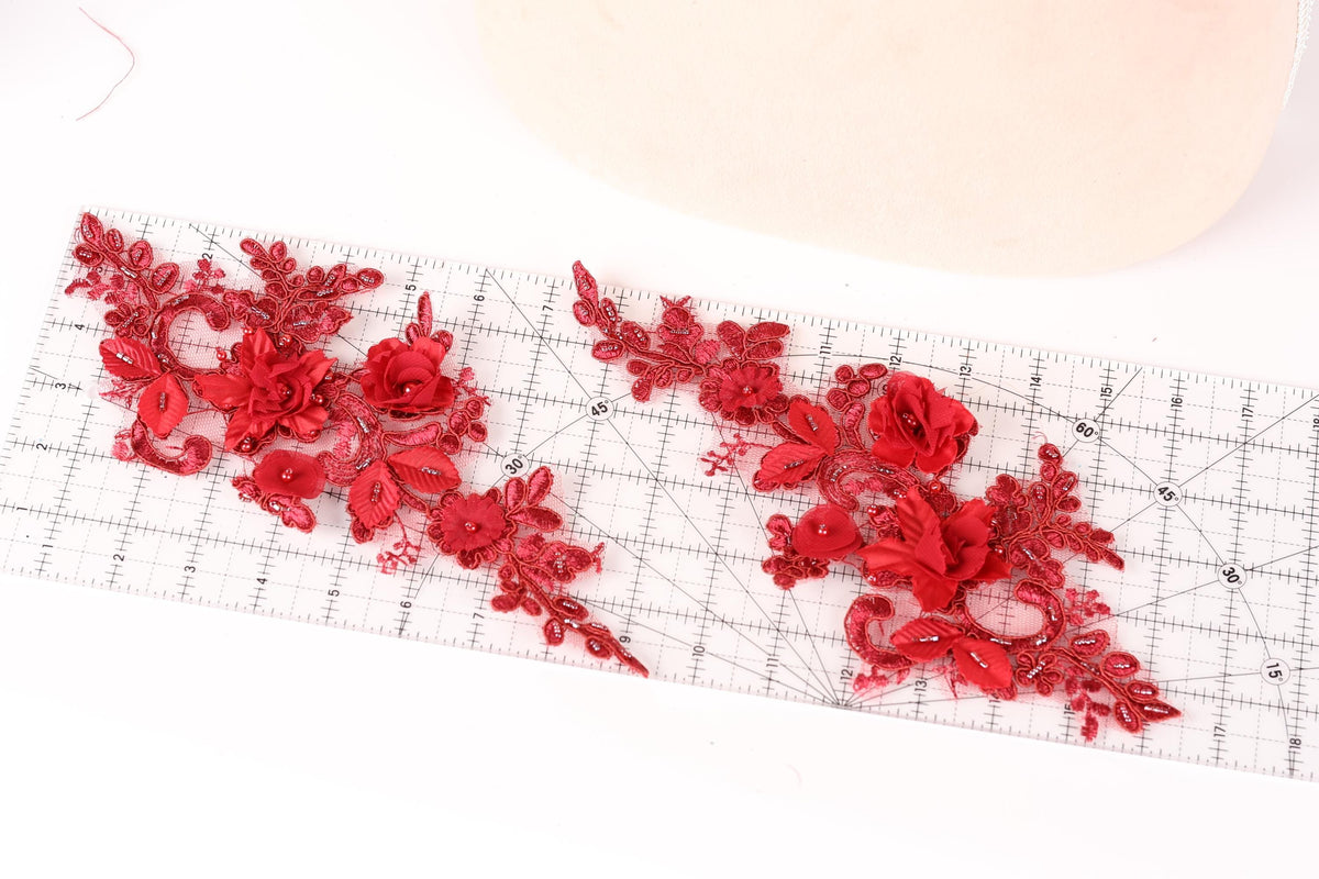 a close-up view of red floral embroidery on a ruler, showcasing intricate details and patterns.