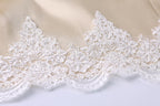 A close-up view of a delicate, intricate white lace trim on a fabric surface.
