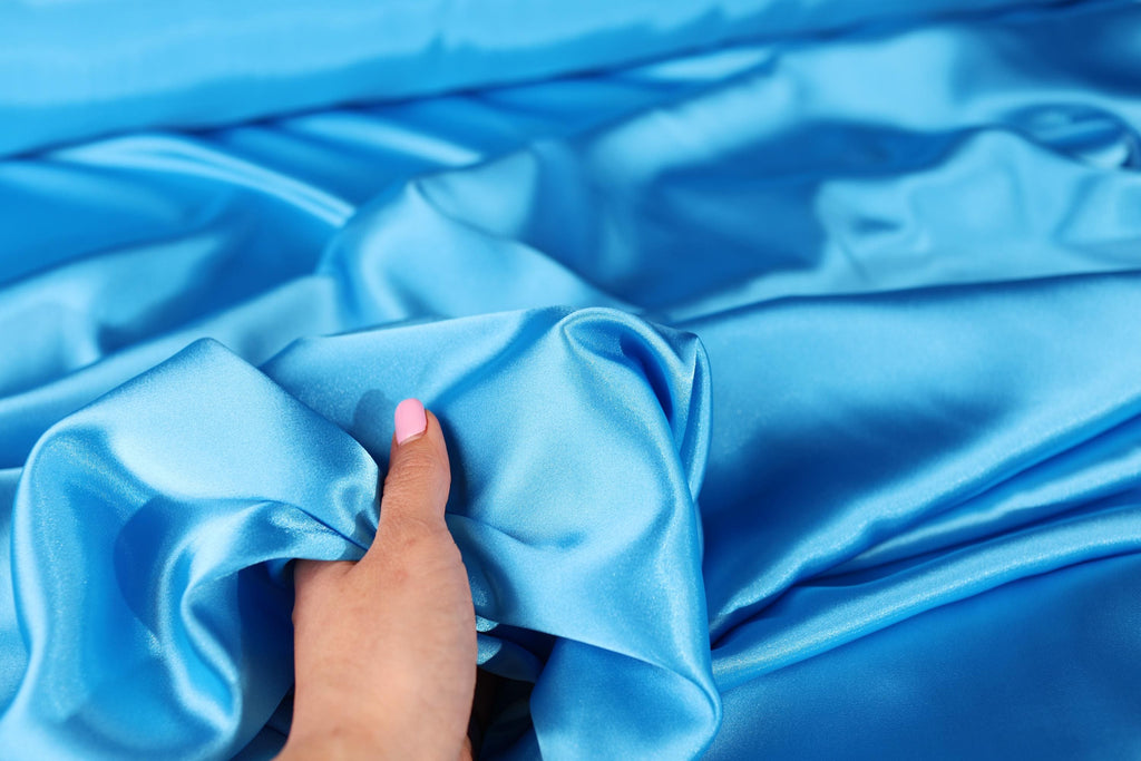 a person&#39;s hand on a blue cloth