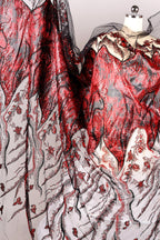 a close-up view of a fabric with a striking red and black pattern, including a mix of sequins and floral designs. The fabric appears to be a sheer material, with a black and white color scheme. The image does not contain any text or other discernible objects or actions.
