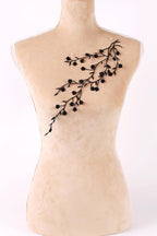 A mannequin with a beige body and a black branch-like design on its chest.