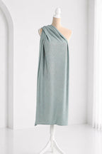 A mannequin wearing a light blue one-shoulder dress with a draped, flowing design.