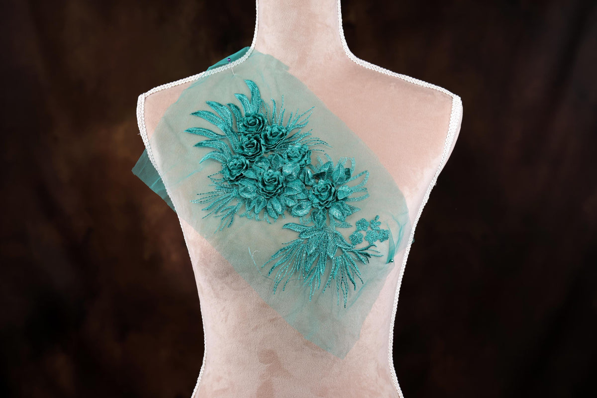 A mannequin with a light pink bust and a green floral embroidered on the back.
