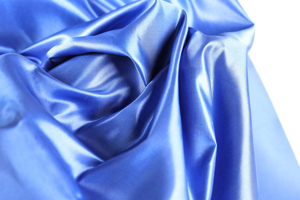 The image is a close-up of a shiny, blue satin fabric.