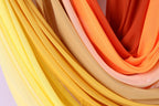a close-up view of colorful fabric, with a mix of yellow, orange, and pink hues. The fabric appears to be folded or draped, creating a visually appealing and textured composition.